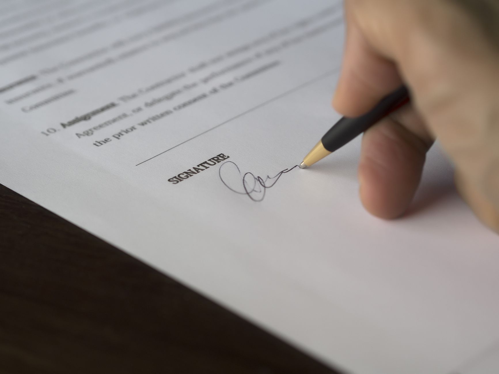 A contract being signed at a desk — the written agreement Article 28 requires before a processor touches personal data.