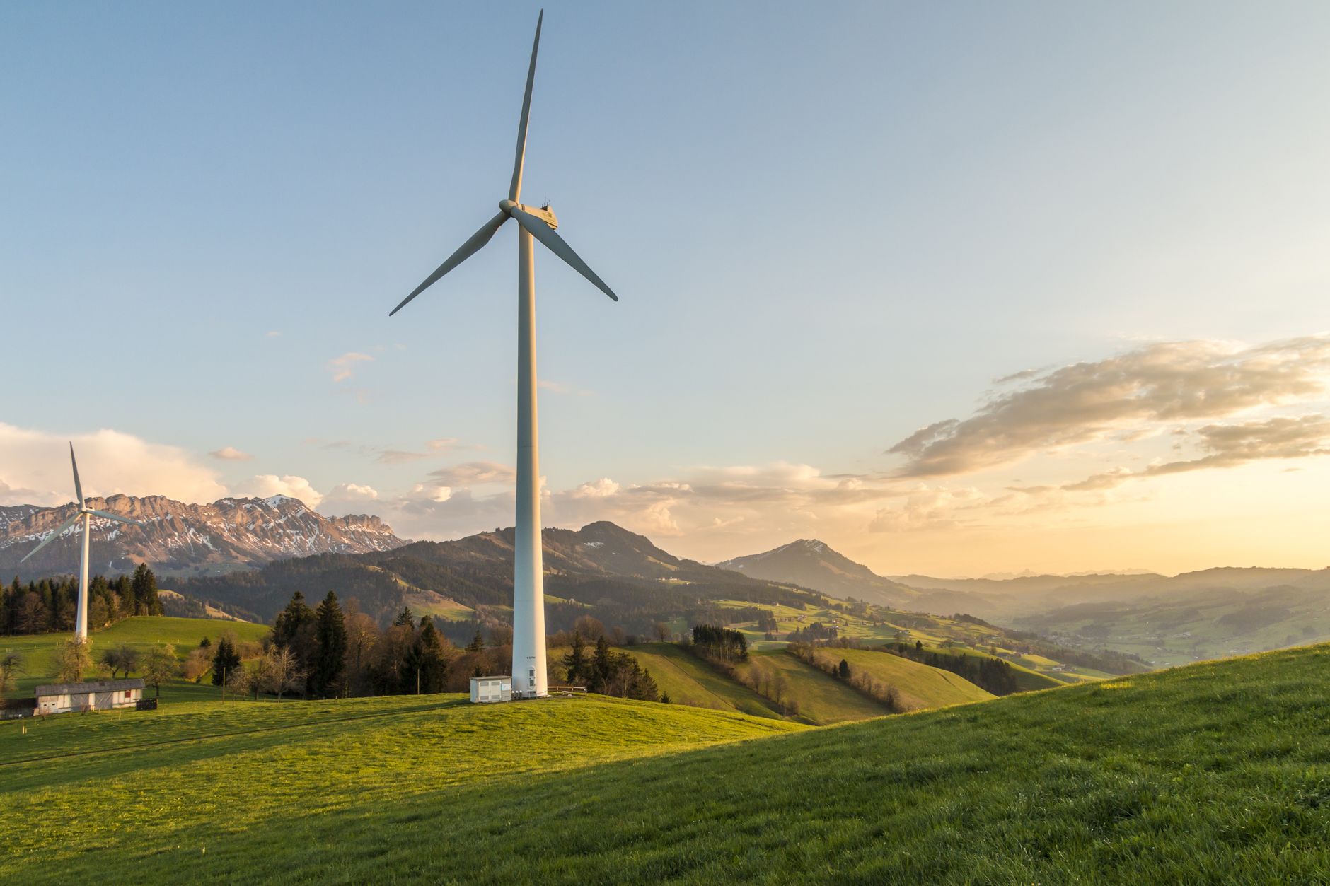 Wind turbines across open countryside at sunset — the environmental performance an ISO 14001 system is built to manage.