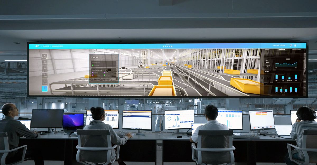 A modern control room where staff monitor large digital displays and computer systems.