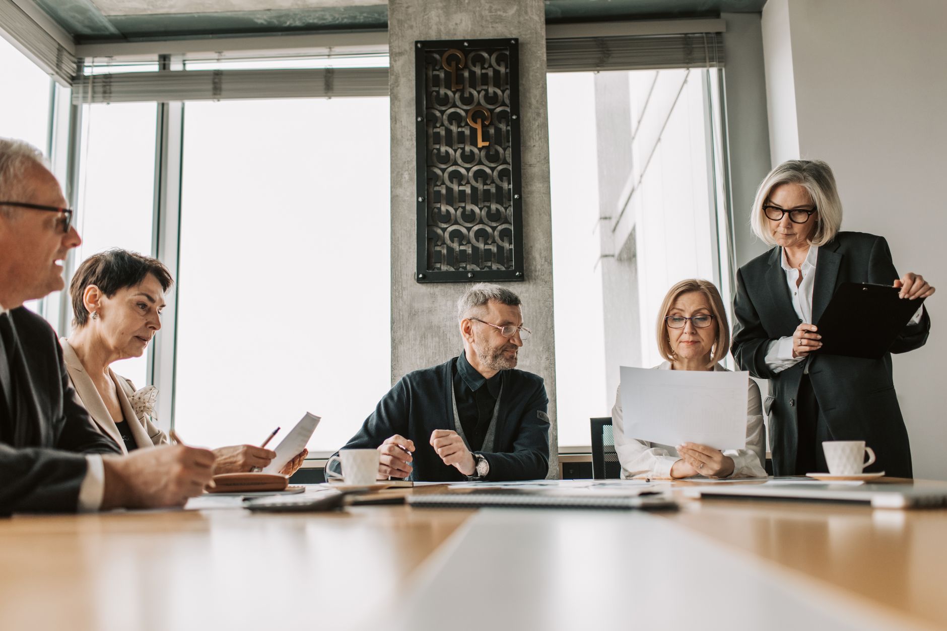 Executives reviewing documents in a meeting room — the level at which a vCISO is accountable.