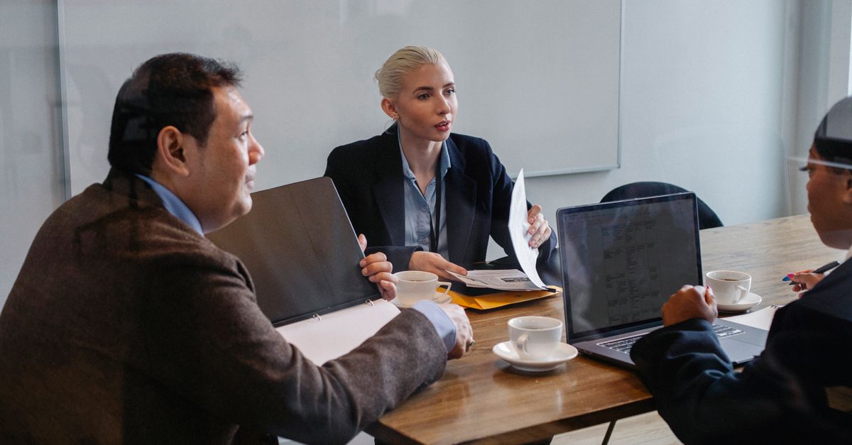 Colleagues meeting around a table — the security leadership a virtual CISO provides at a fraction of a full-time cost.